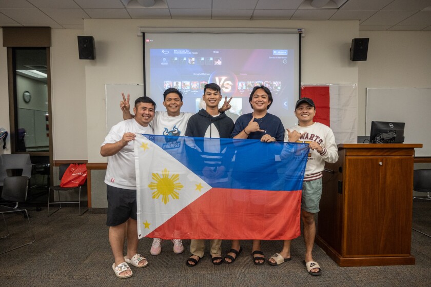 Cinco homens posam com a bandeira filipina.