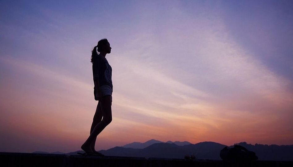 Mulher olhando o horizonte pensando na teologia das segundas chances. 