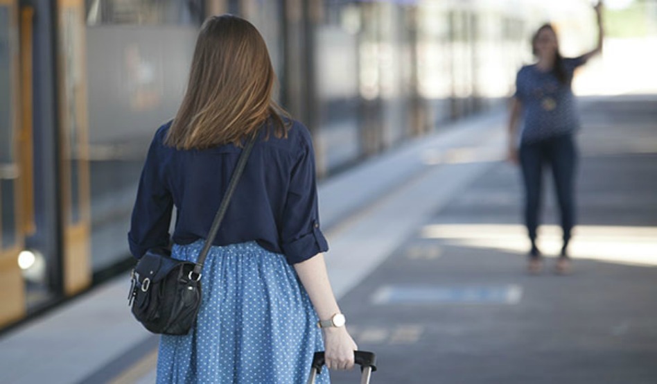 Missionária com uma pessoa ao fundo acenando 
